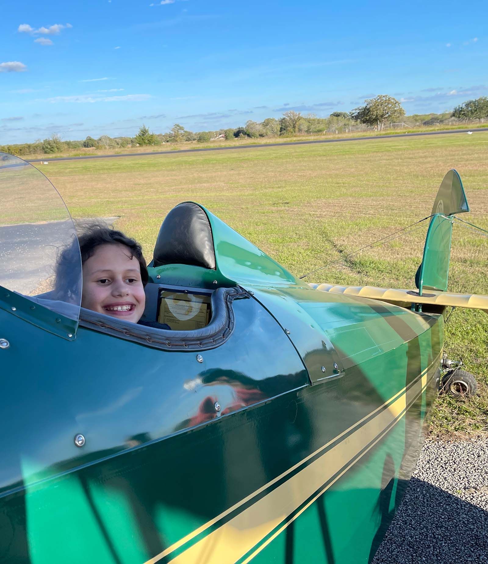 close up of smiling girl in the open cockpit of a 1929 fleet biplane